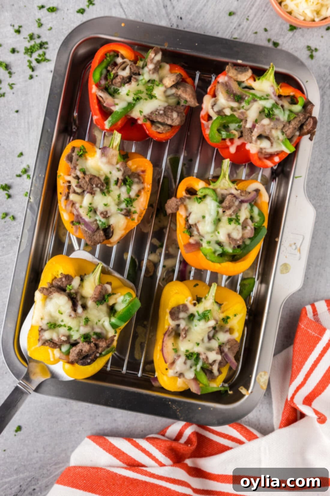 Spatula picking up a Philly Cheesesteak Stuffed Pepper off a pan of Philly Cheesesteak Stuffed Peppers