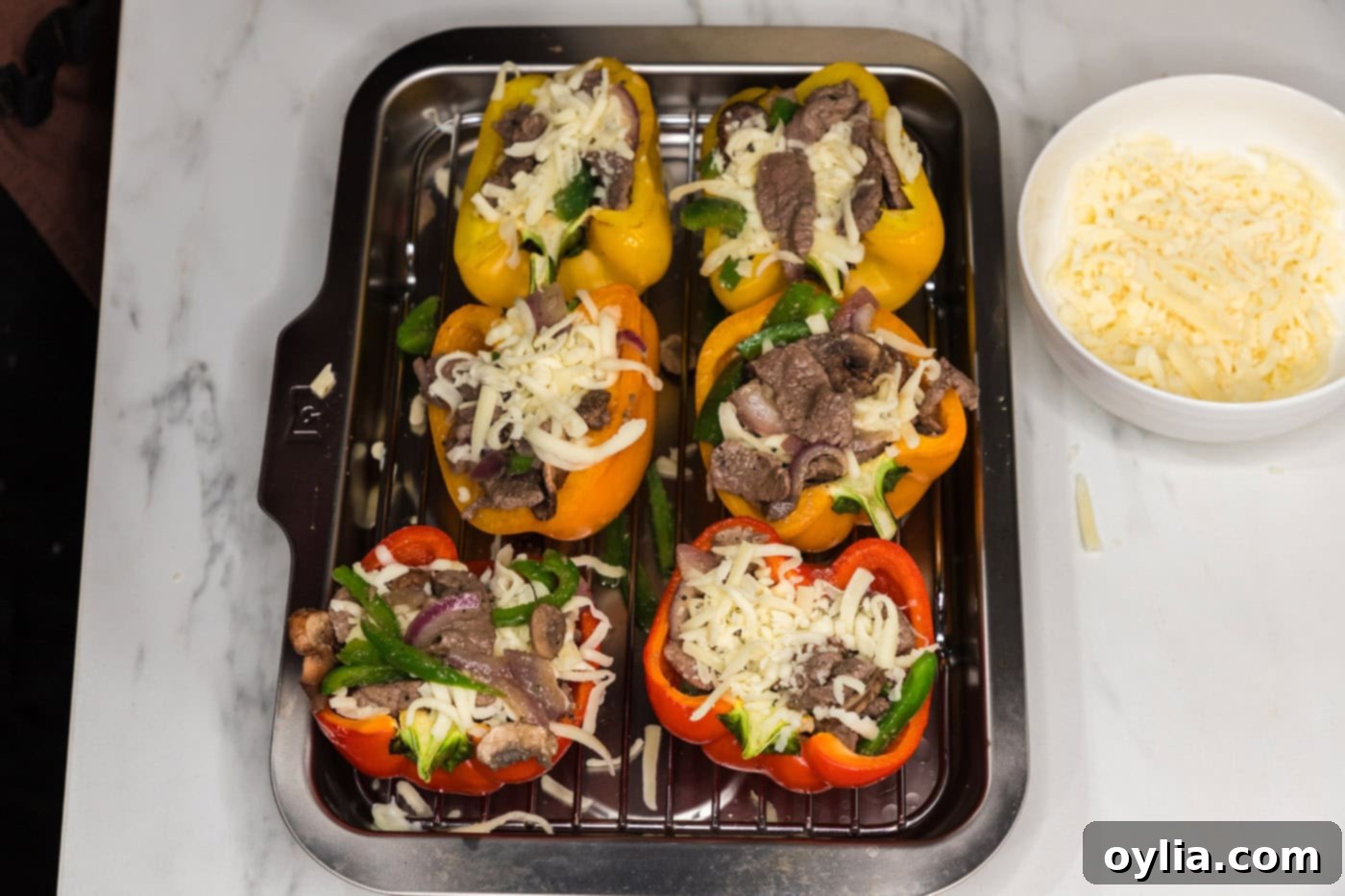 steak and onion mixture added on top of sliced bell peppers with cheese, before the final cheese layer