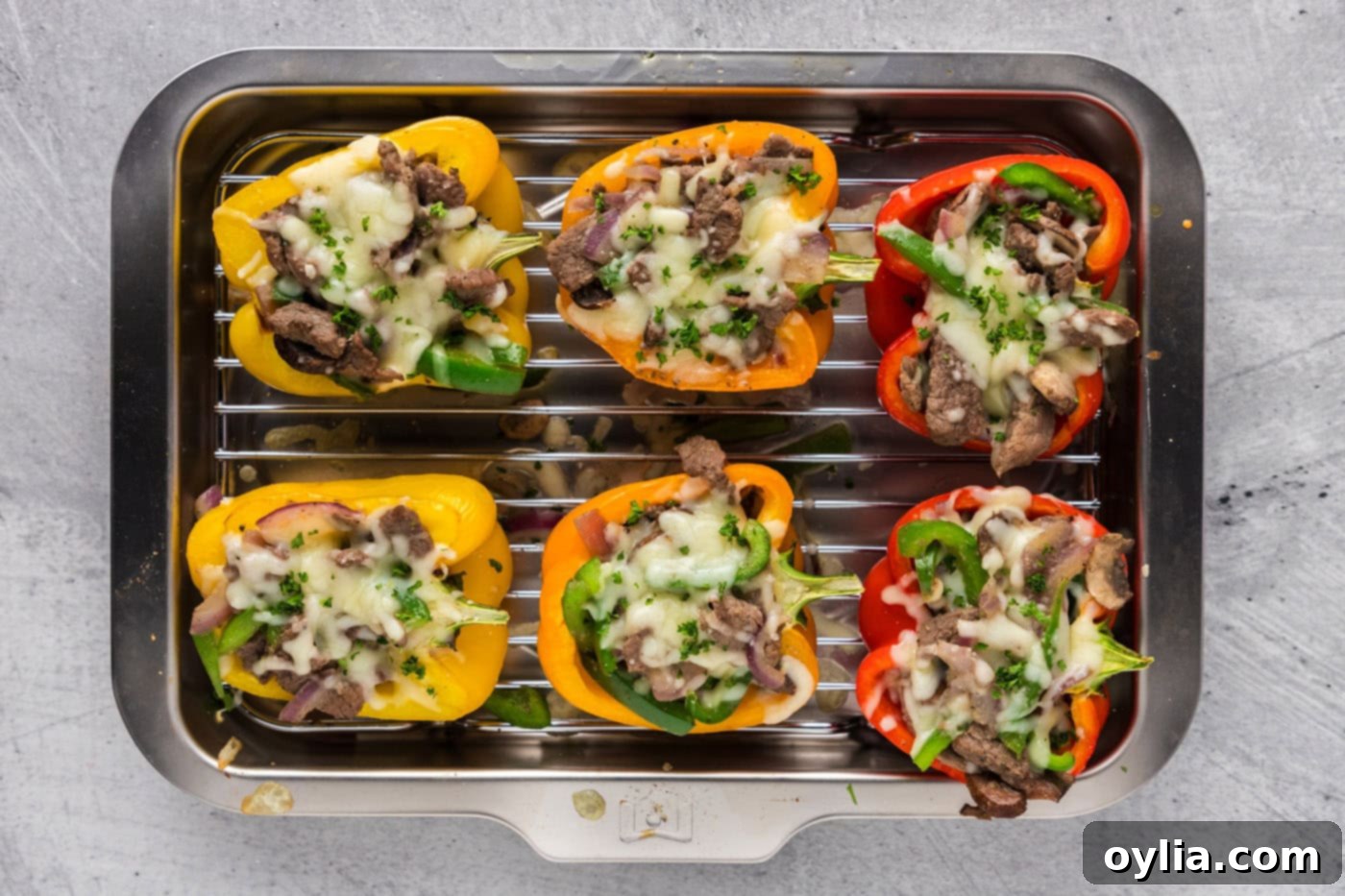 baked overhead shot of philly cheesesteak stuffed peppers in a baking dish, with melted and browned cheese