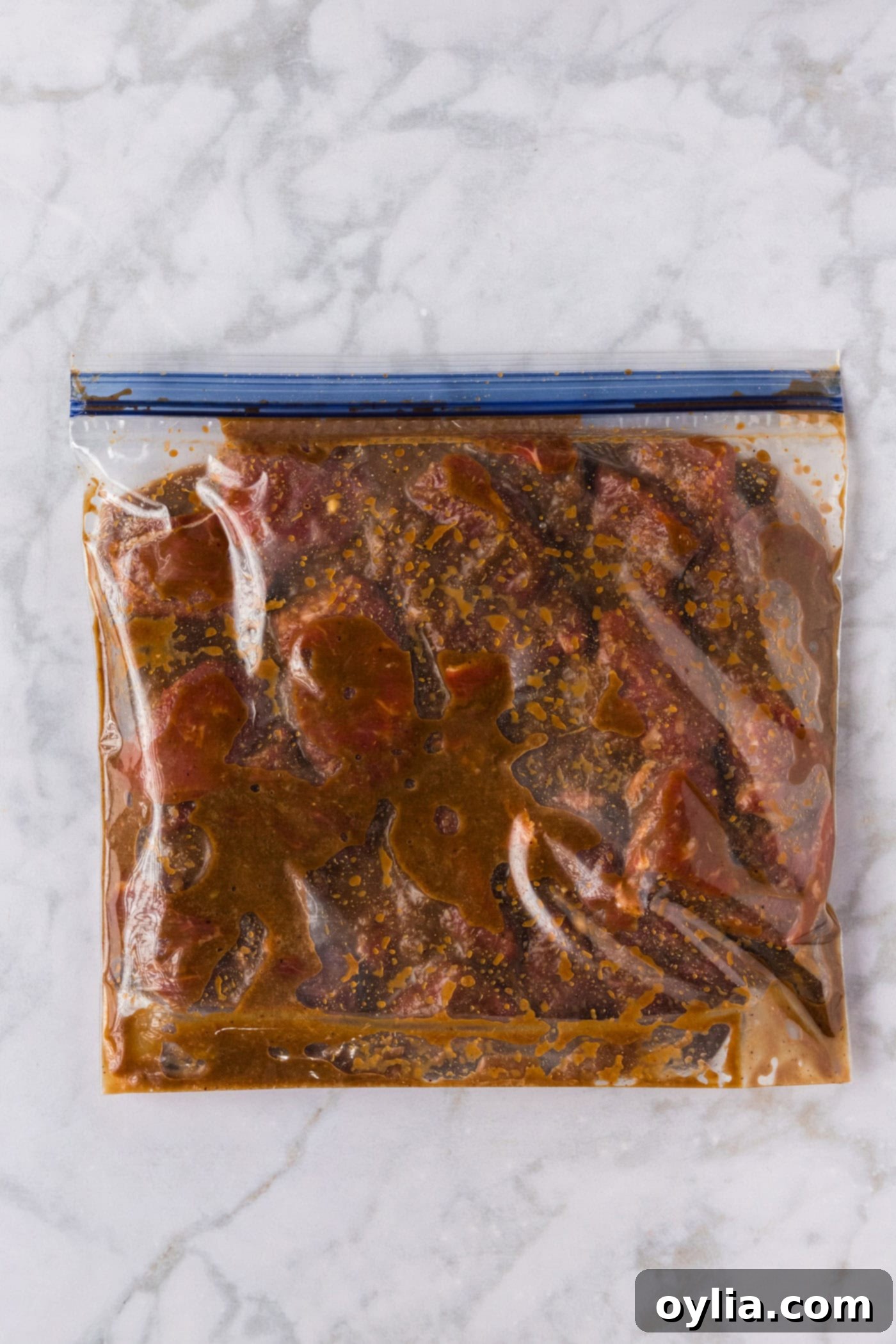 sliced steak in a ziptop bag with brown sugar bourbon marinade
