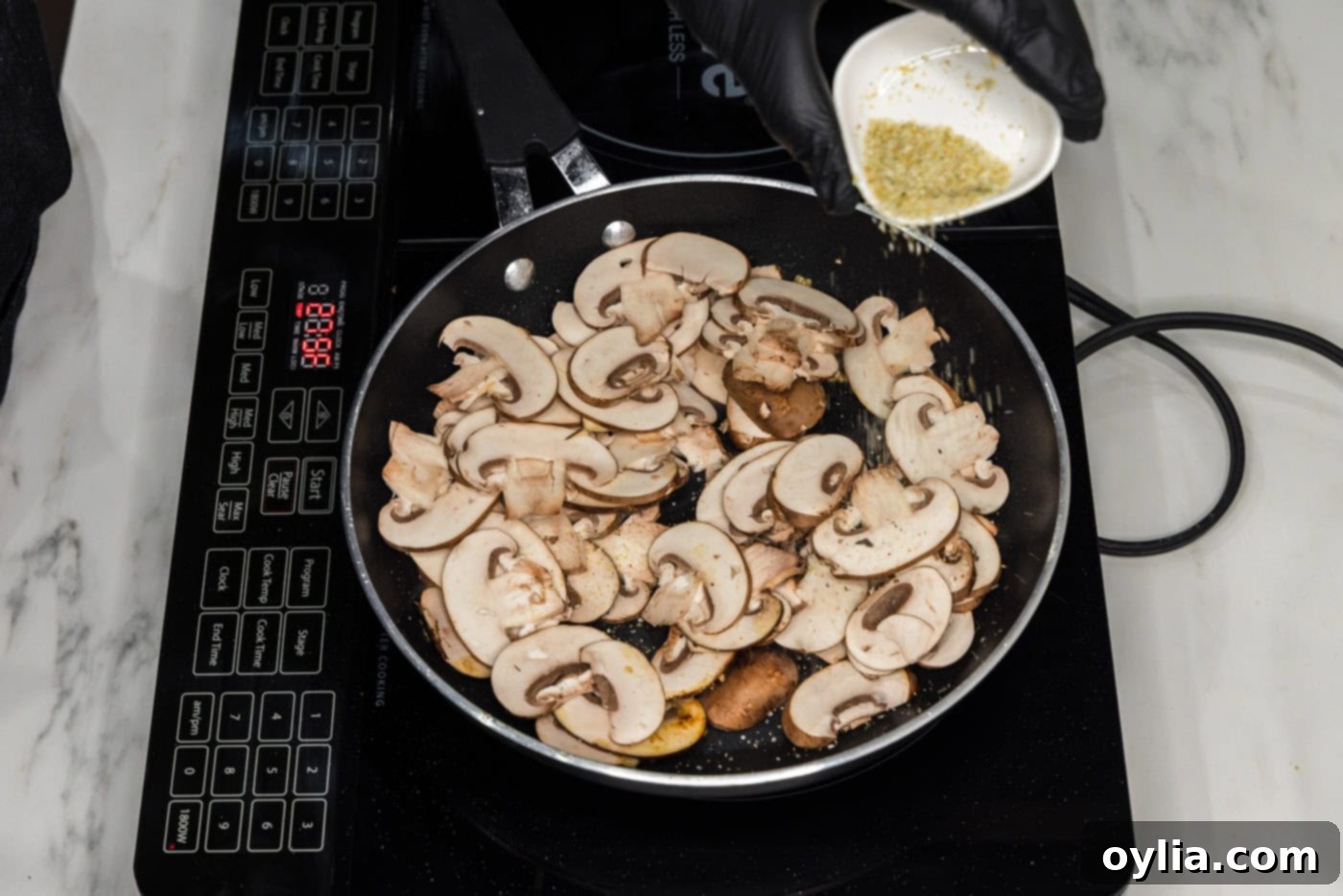 sliced mushrooms cooking in a skillet with oil