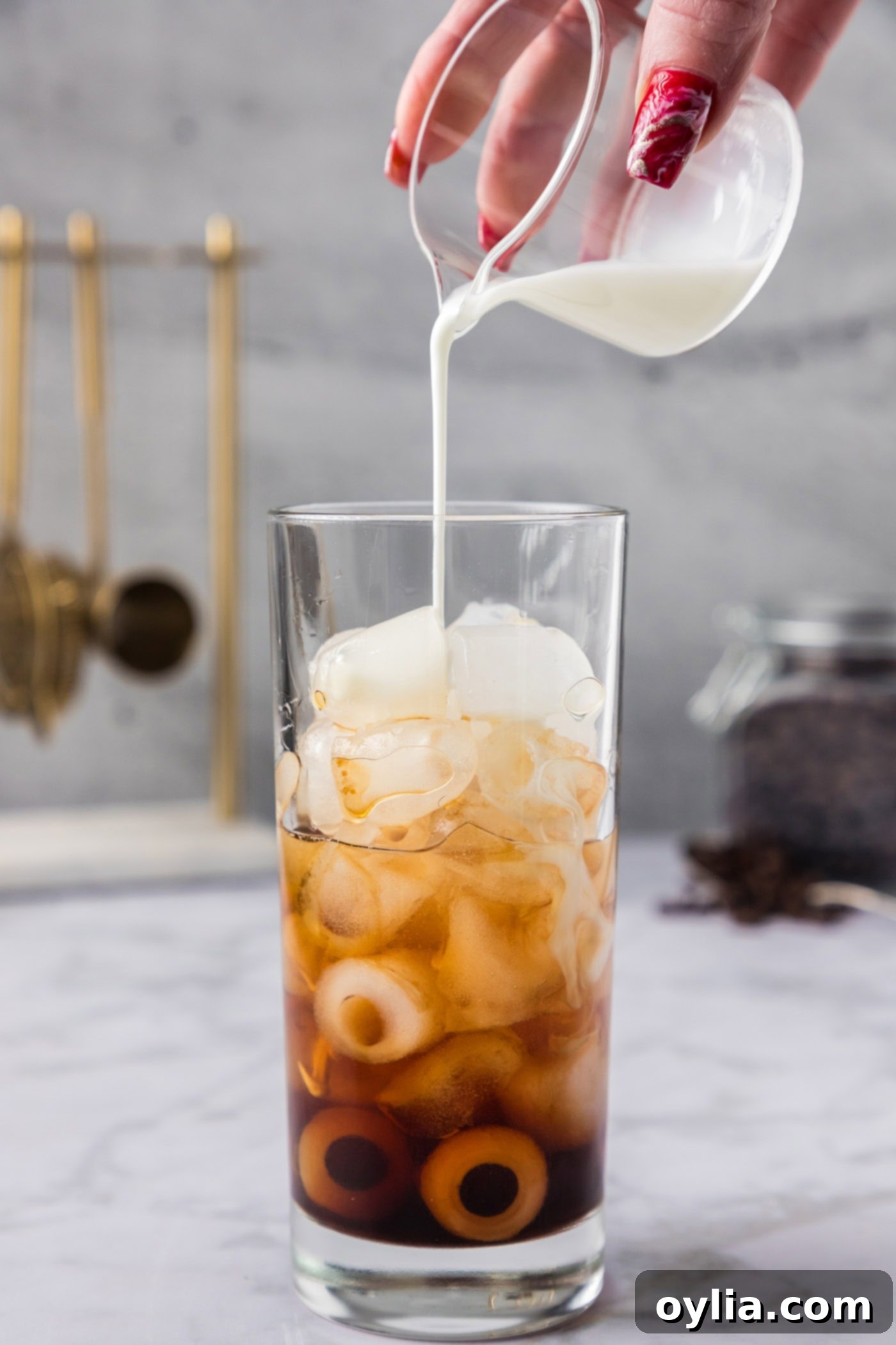 pouring half and half into glass of ice with Kahlua and vodka
