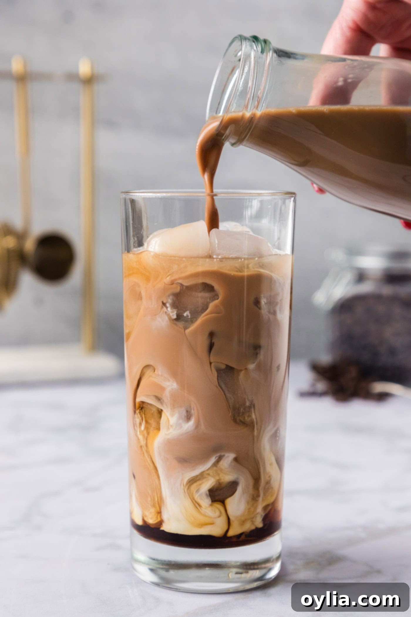 pouring iced coffee into glass of ice with Kahlua and vanilla vodka