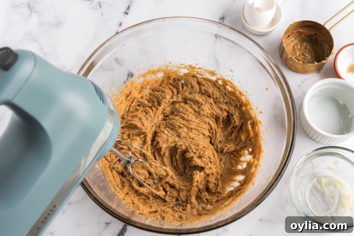 beating egg into peanut butter cookie dough in a bowl