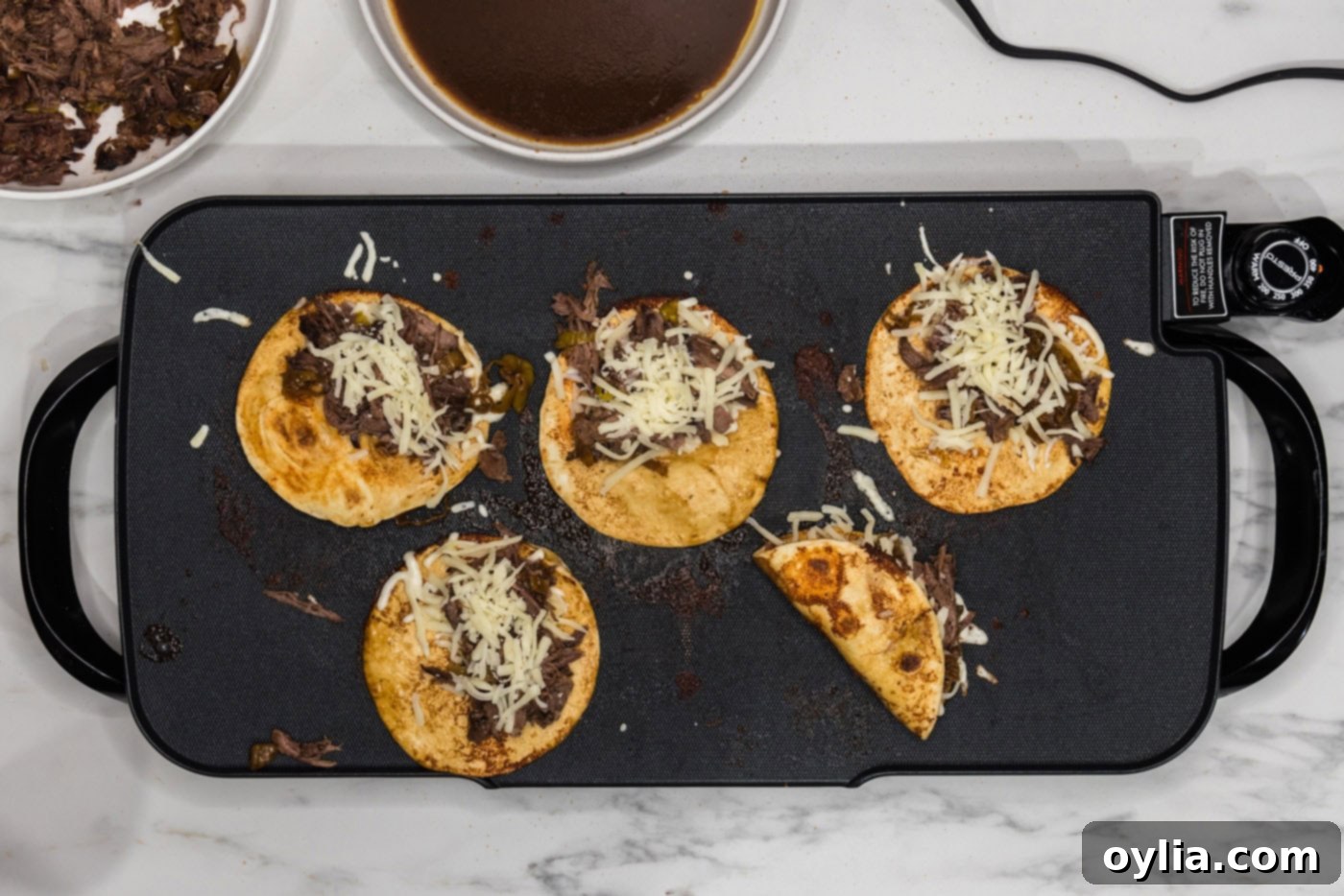 A spatula folding a Mississippi pot roast taco, enclosing beef and cheese inside a crispy tortilla