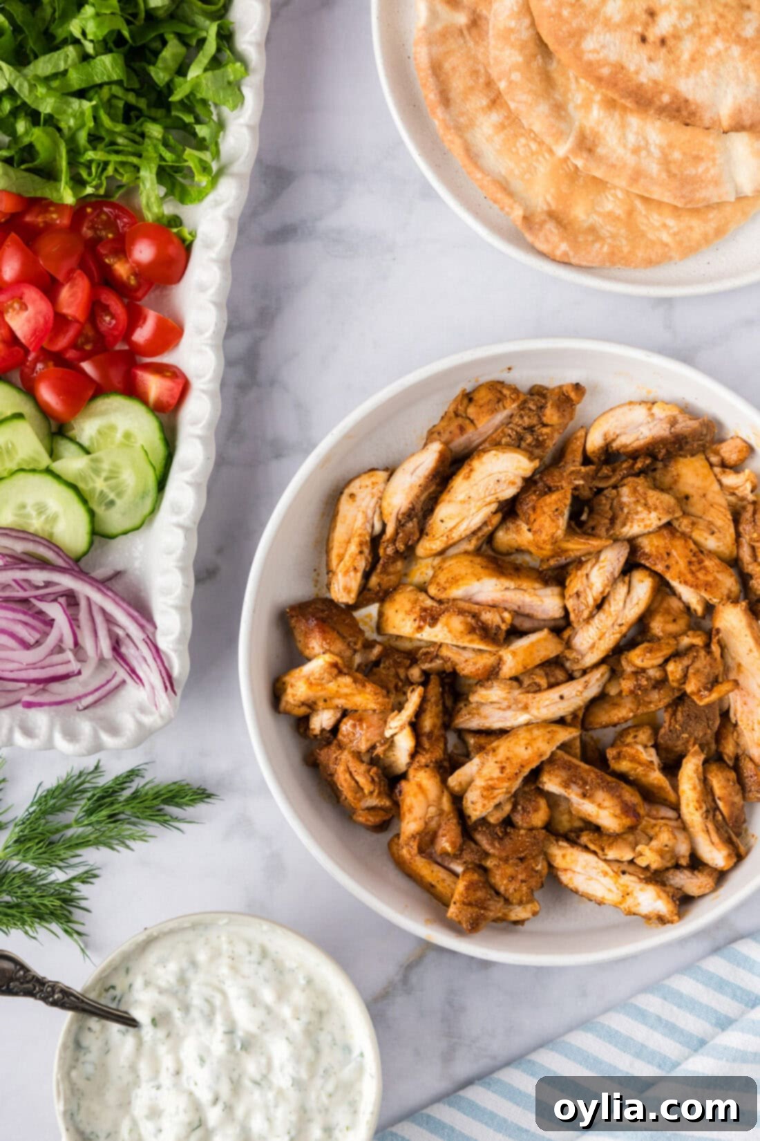 Homemade Chicken Shawarma 2 Chicken Shawarma in a bowl with tzatziki, hummus and veggies on the side