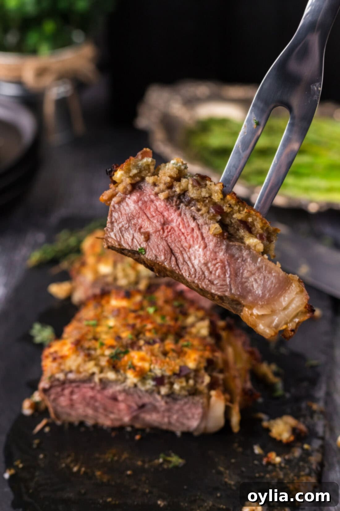Blue Cheese Crowned Steak 12 Meat fork lifting up a piece of Blue Cheese Crusted Steak