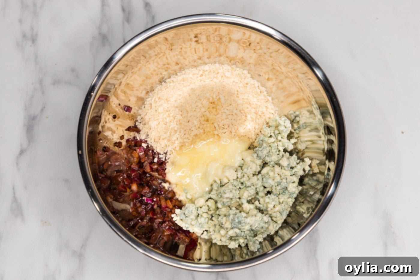 panko, blue cheese crumbles, and red onionmixture in a mixing bowl with butter