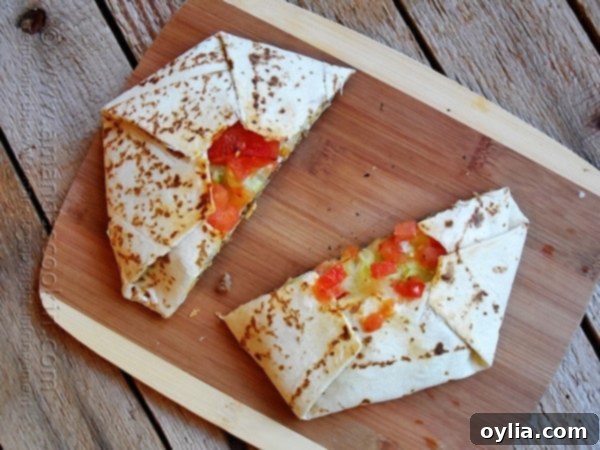 A perfectly grilled homemade Crunchwrap Supreme cut in half, showcasing its layers.