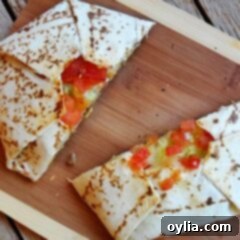 Ultimate Homemade Crunchwrap Supreme 13 A beautifully presented copycat Crunchwrap Supreme, sliced in half to show all the delicious layers, on a rustic wooden cutting board.