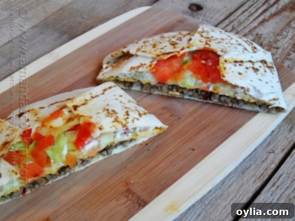 A homemade Crunchwrap Supreme, sliced in half to reveal its mouth-watering layers.