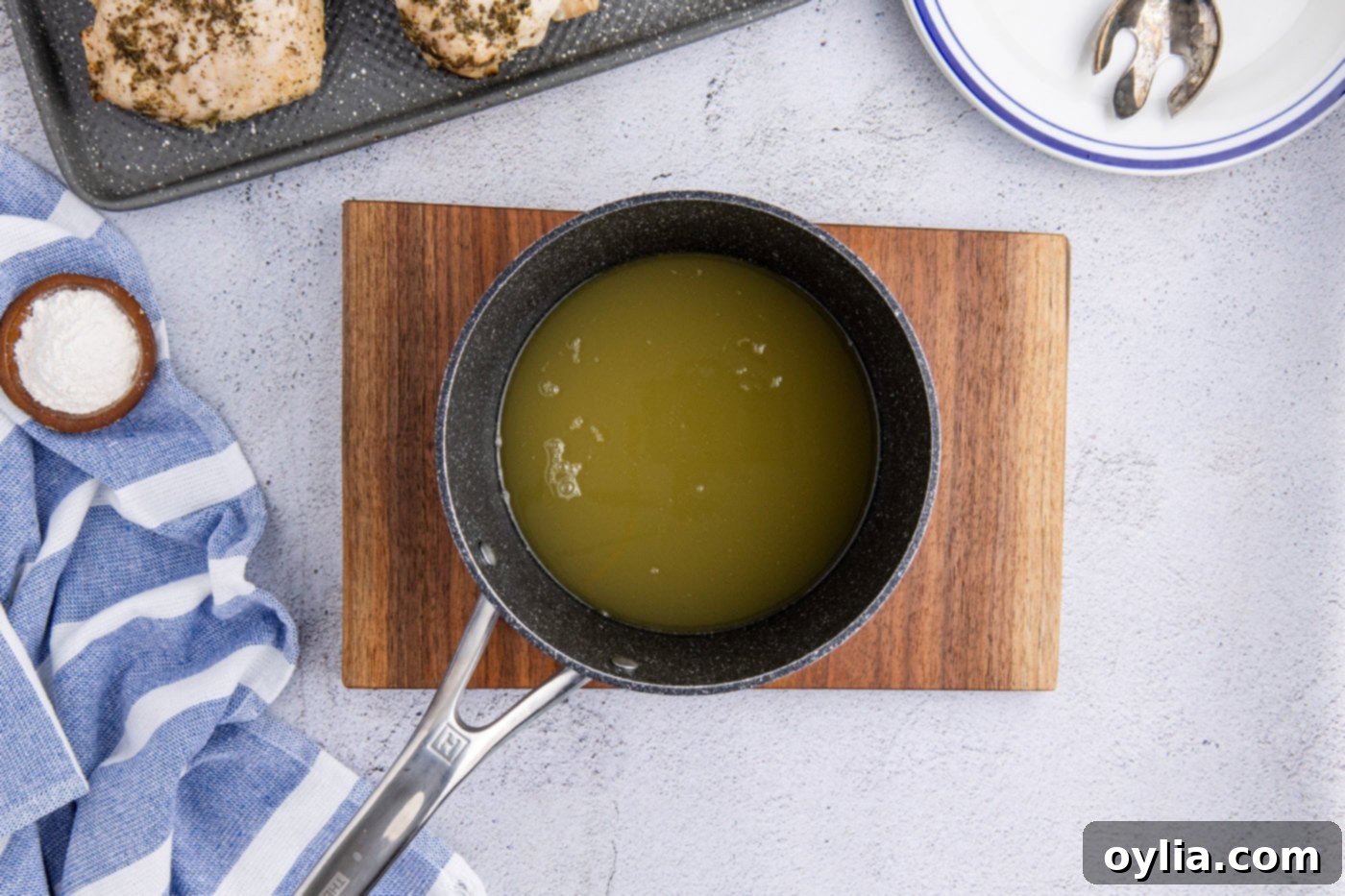 apple cider and chicken stock in a saucepan