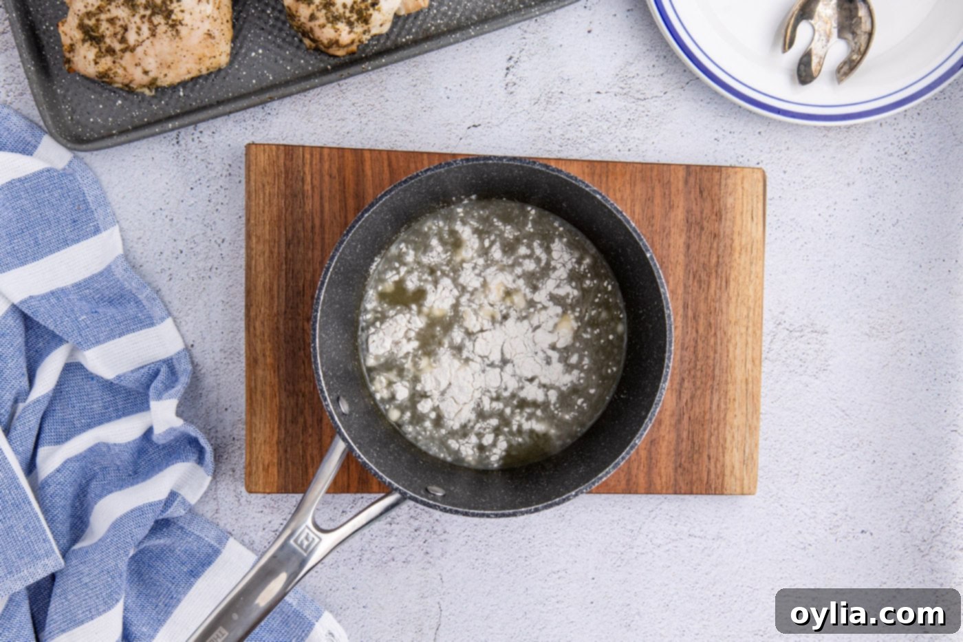 adding flour to chicken stock and apple cider mixture