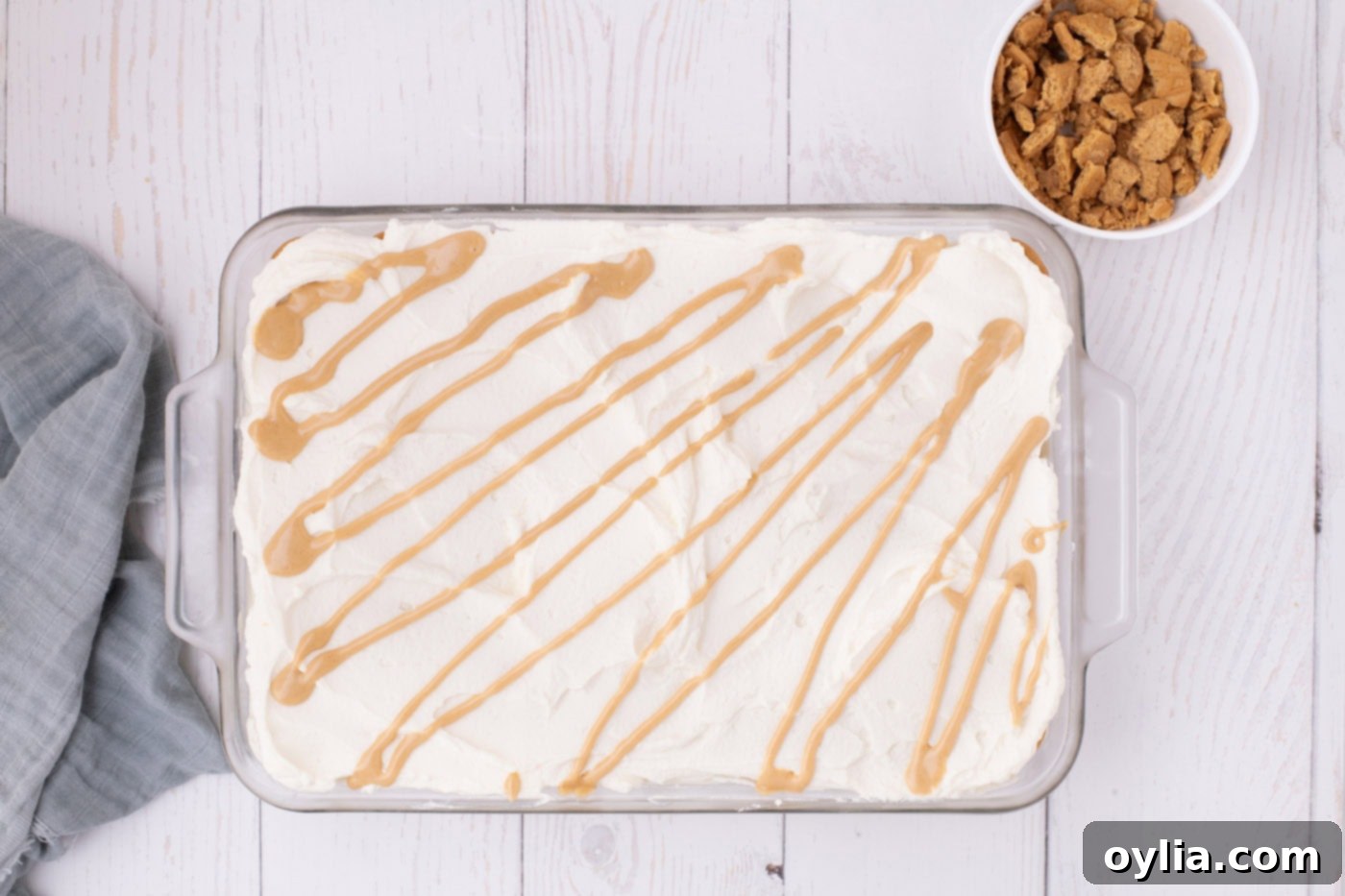 peanut butter drizzle over no bake nutter butter icebox cake in a pan