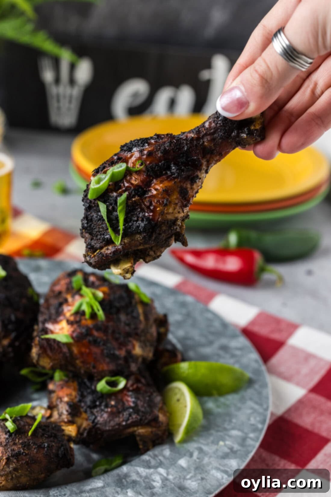 Hand holding up a piece of Jerk Chicken