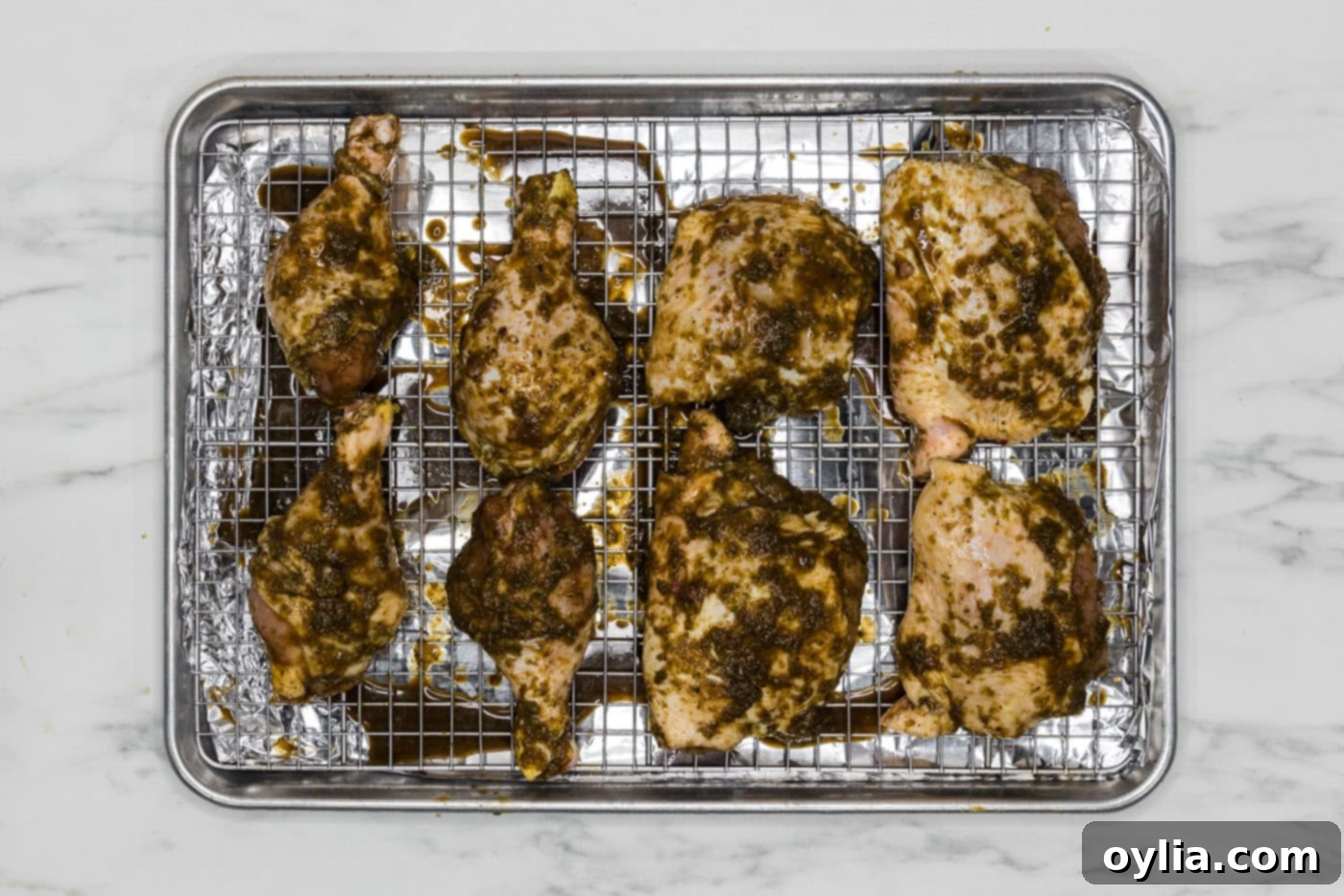 marinated jerk chicken on a wire rack over a baking sheet