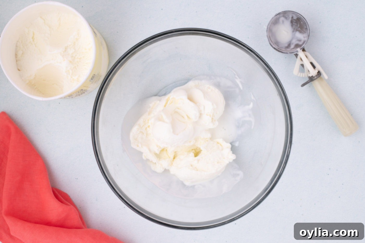 Softened vanilla ice cream in a large mixing bowl, ready for flour