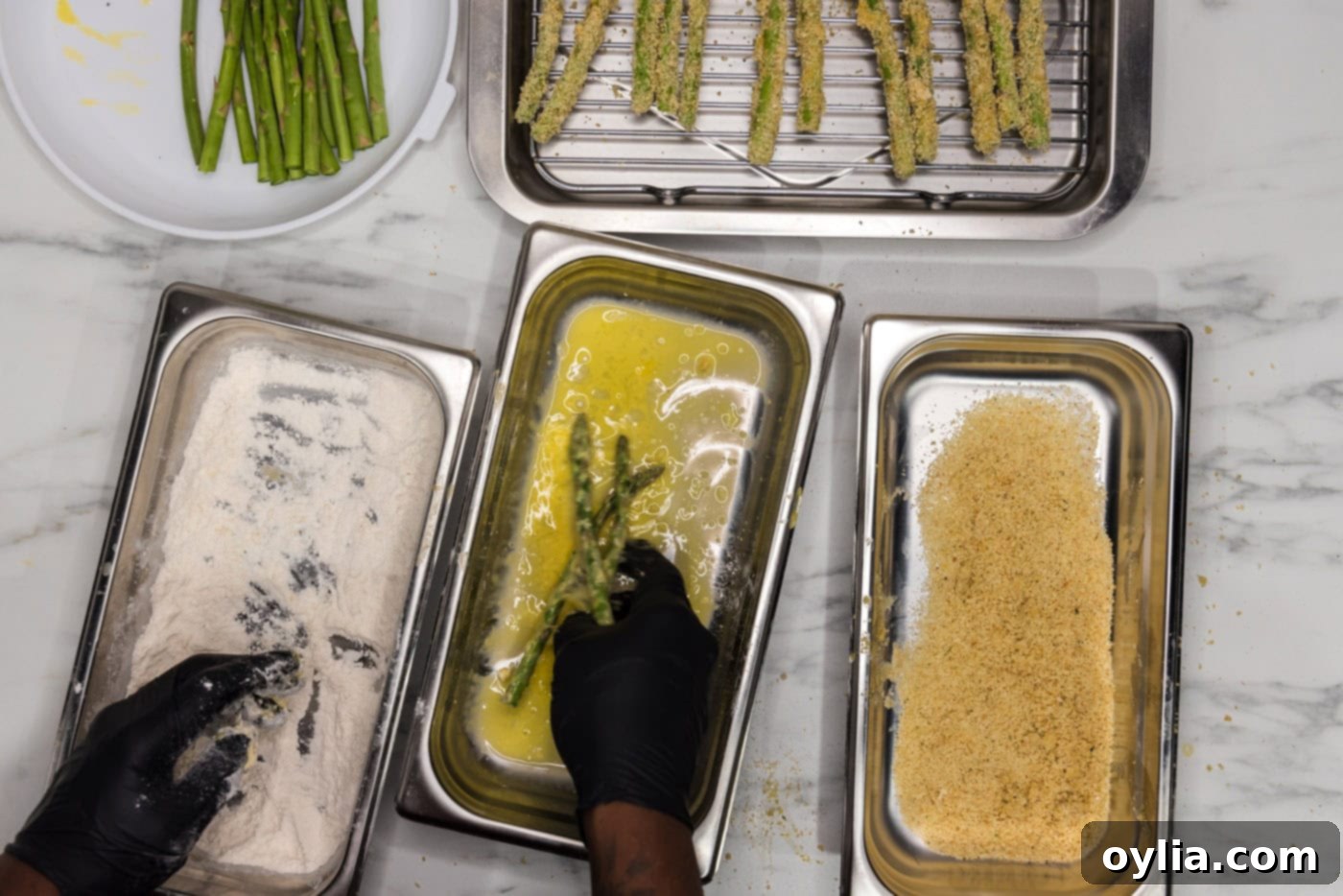 dredging asparagus spears in egg