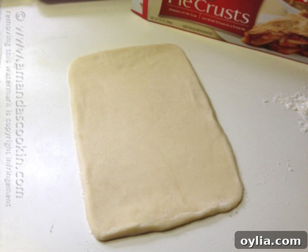 Pie dough rolled out into an approximate 10x6 inch rectangle on a floured surface