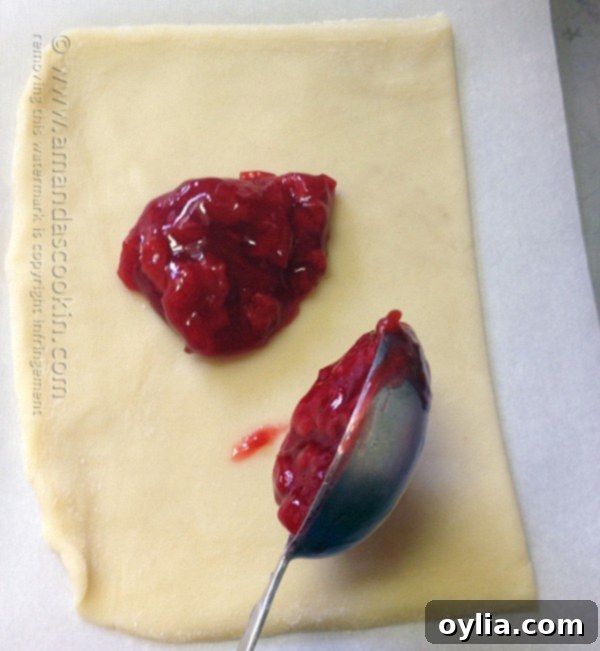 Two tablespoons of cherry pie filling spooned onto each dough rectangle