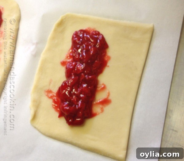 Dough folded over cherry filling and edges pressed shut with fingers
