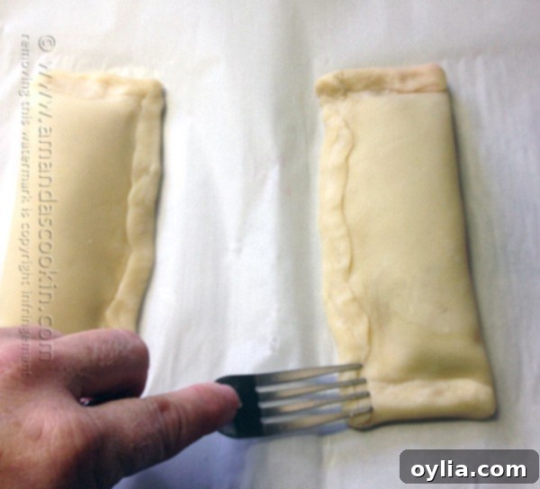 Edges of the cherry hand pie crimped with a fork for a decorative and secure seal