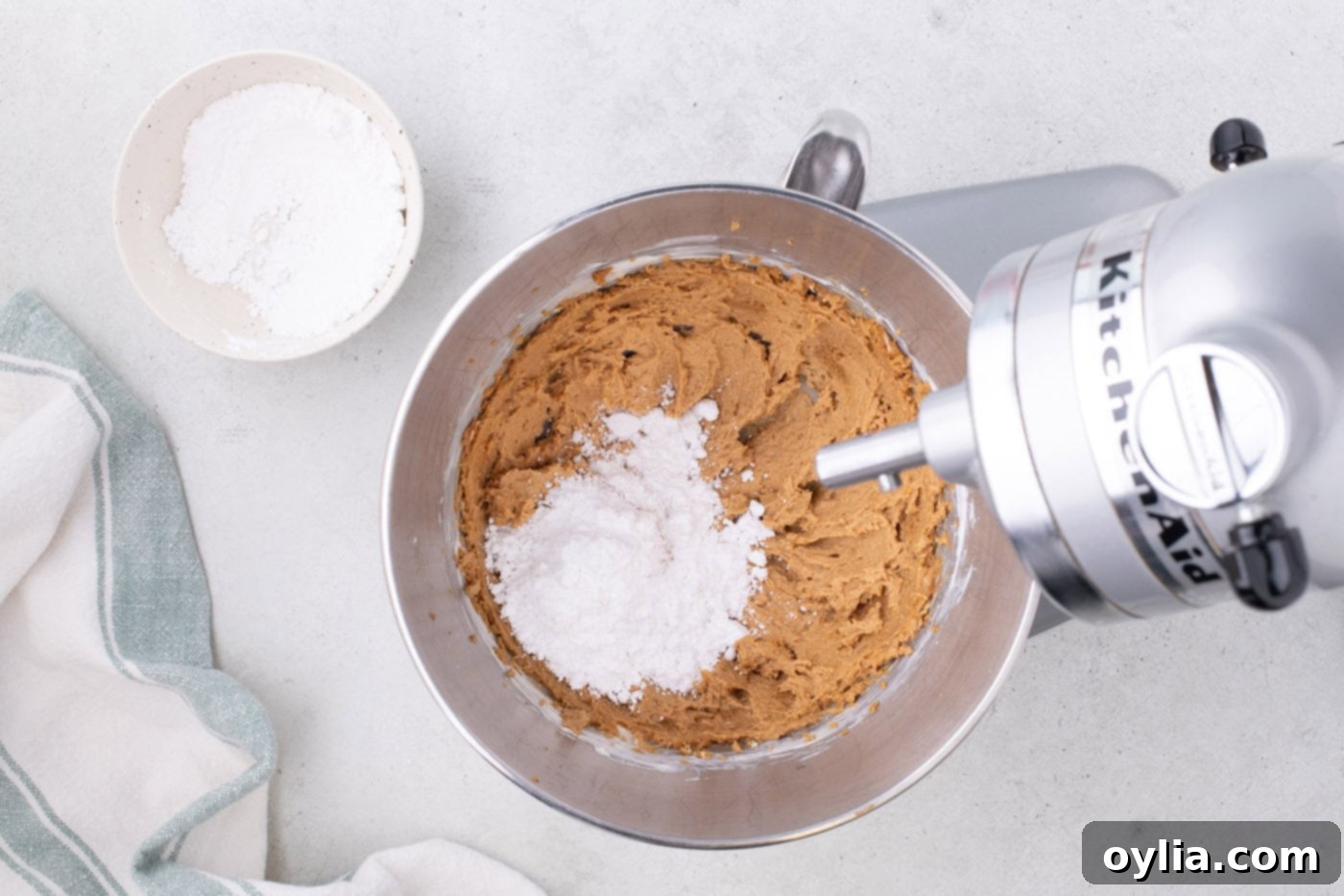 combining powdered sugar with cookie butter and cream cheese mixture in a mixer bowl
