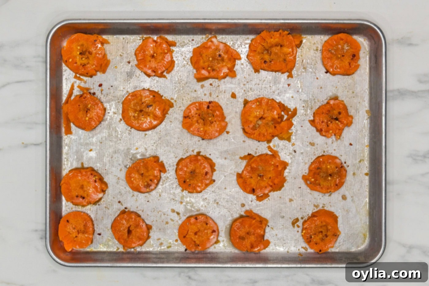 seasoned smashed carrots on a baking sheet