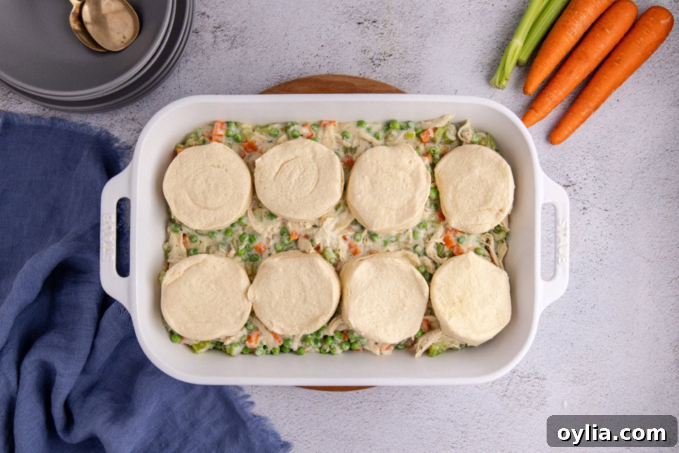 chicken pot pie topped with biscuits in a casserole dish