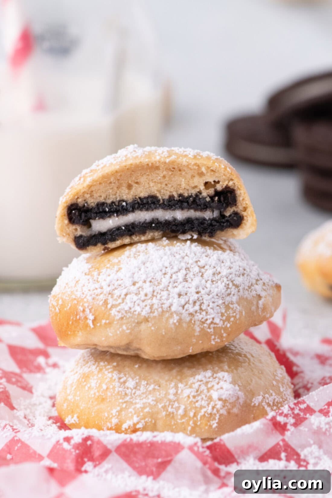 An Air Fryer Oreo cut in half resting on two more Air Fryer Oreos