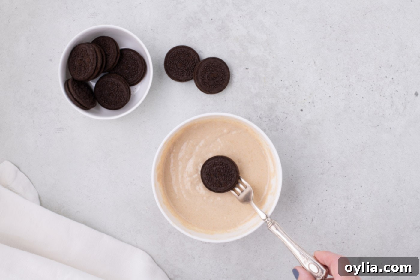 dipping an Oreo into pancake batter with a fork