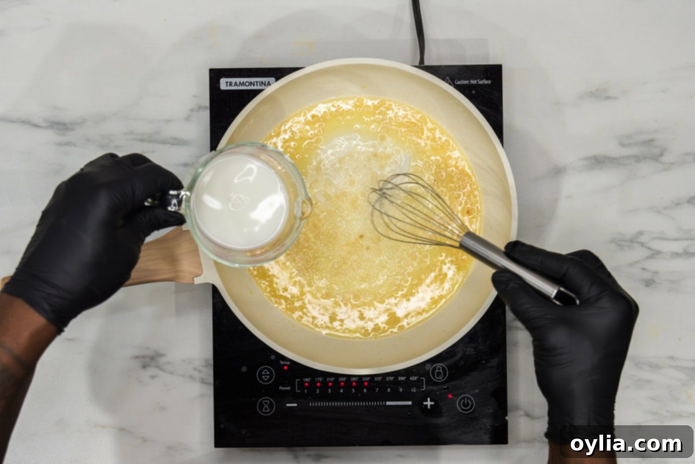 whisking cornstarch into satueed garlic and butter in a skillet to create a creamy sauce