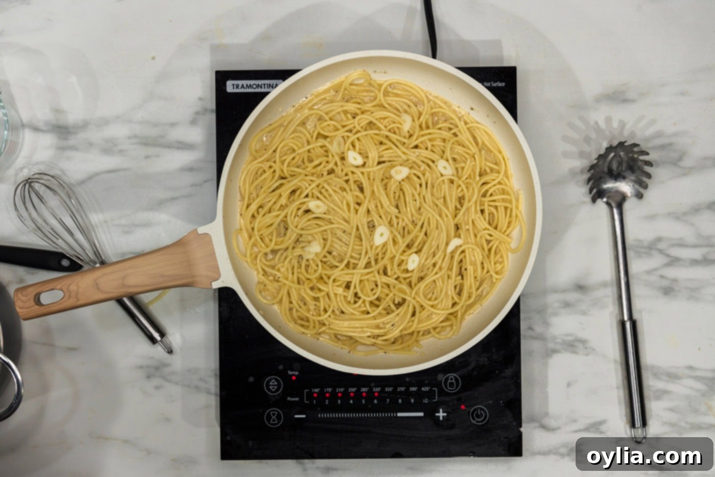 slivered garlic added to pasta with garlic butter sauce in a skillet for extra fresh flavor