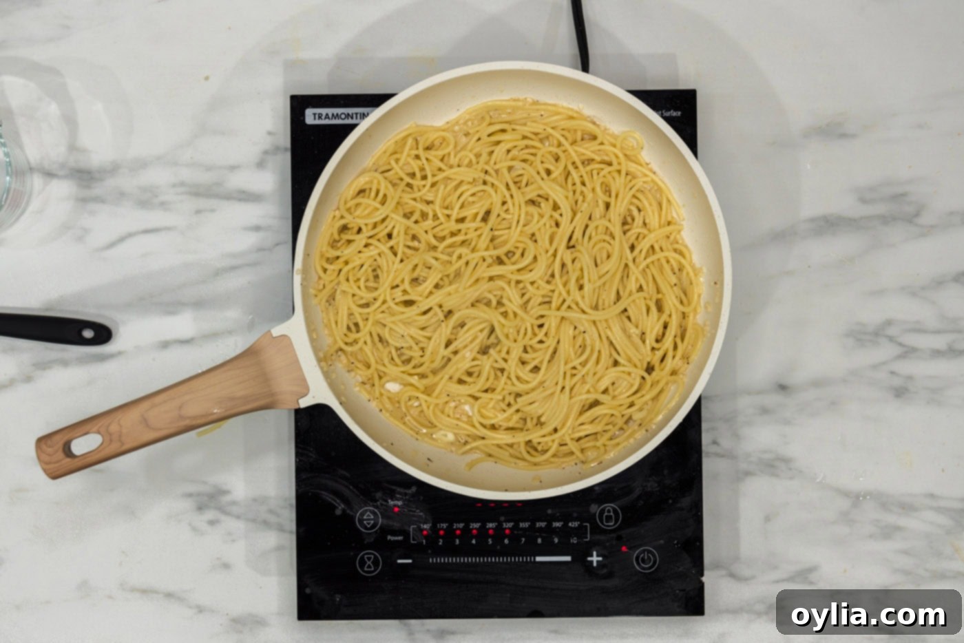 finished garlic butter pasta simmering in a skillet on a burner, ready to be served