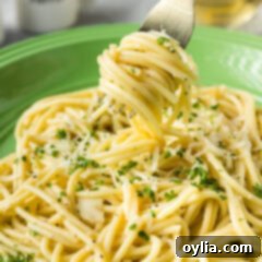 Buttery Garlic Noodle Bliss 10 Garlic Butter Pasta twirled on a fork held above a plate of Garlic Butter Pasta, showing its rich sauce