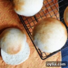 Soft and Fluffy Homemade Burger Buns 12 An overhead photo of homemade hamburger buns on a cooling rack.