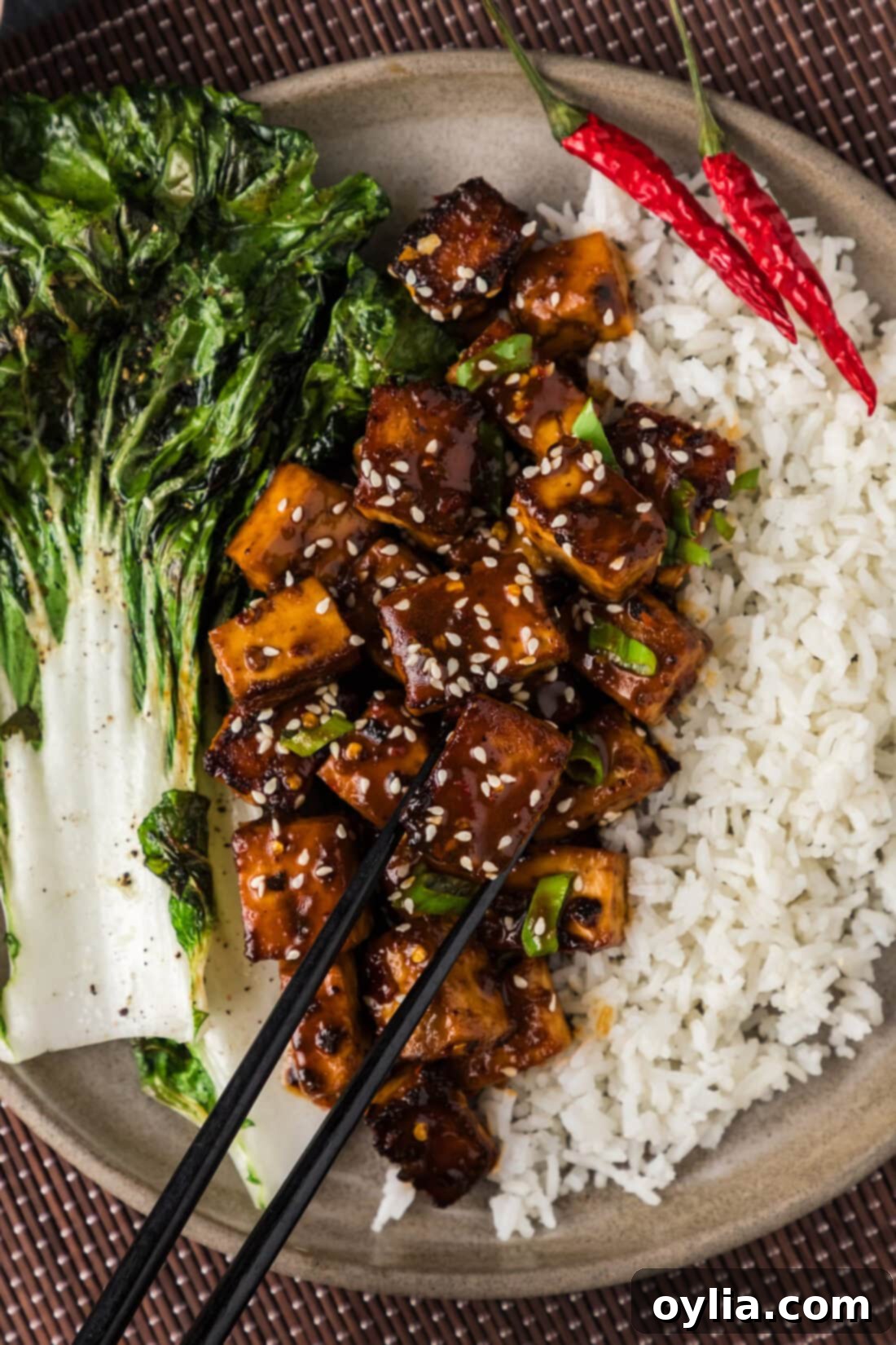 Close up photo of Spicy Tofu on a plate with rice and chopsticks