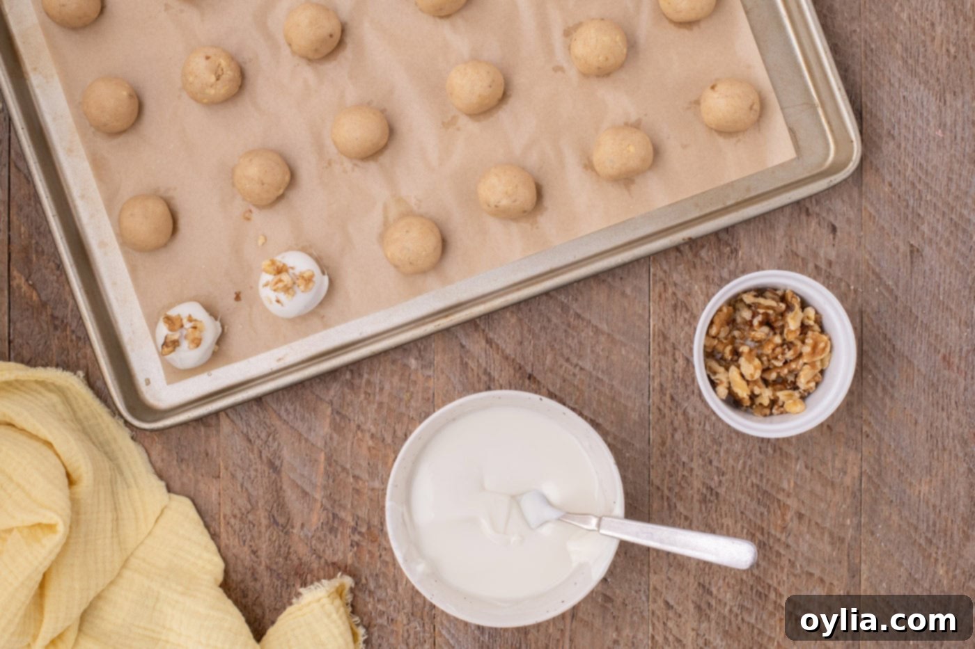 white chocolate coated banana truffles with walnuts on a baking sheet