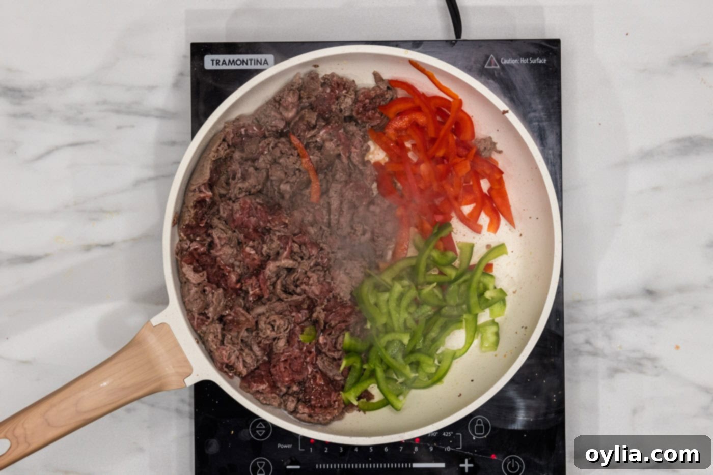 bell peppers in a skillet with shaved beef