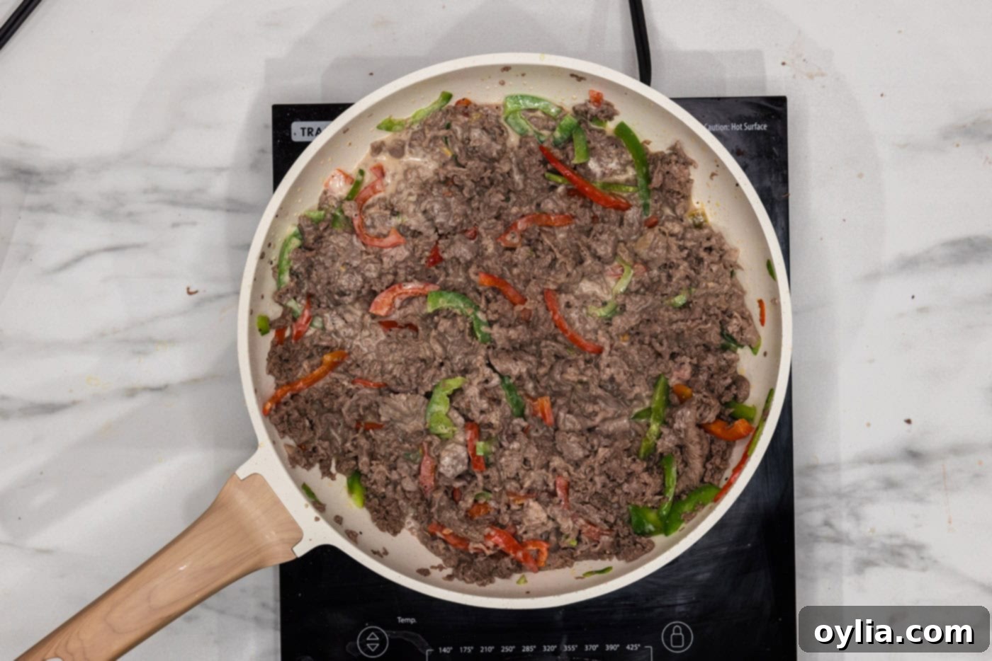 bell peppers, beef, and queso in a skillet