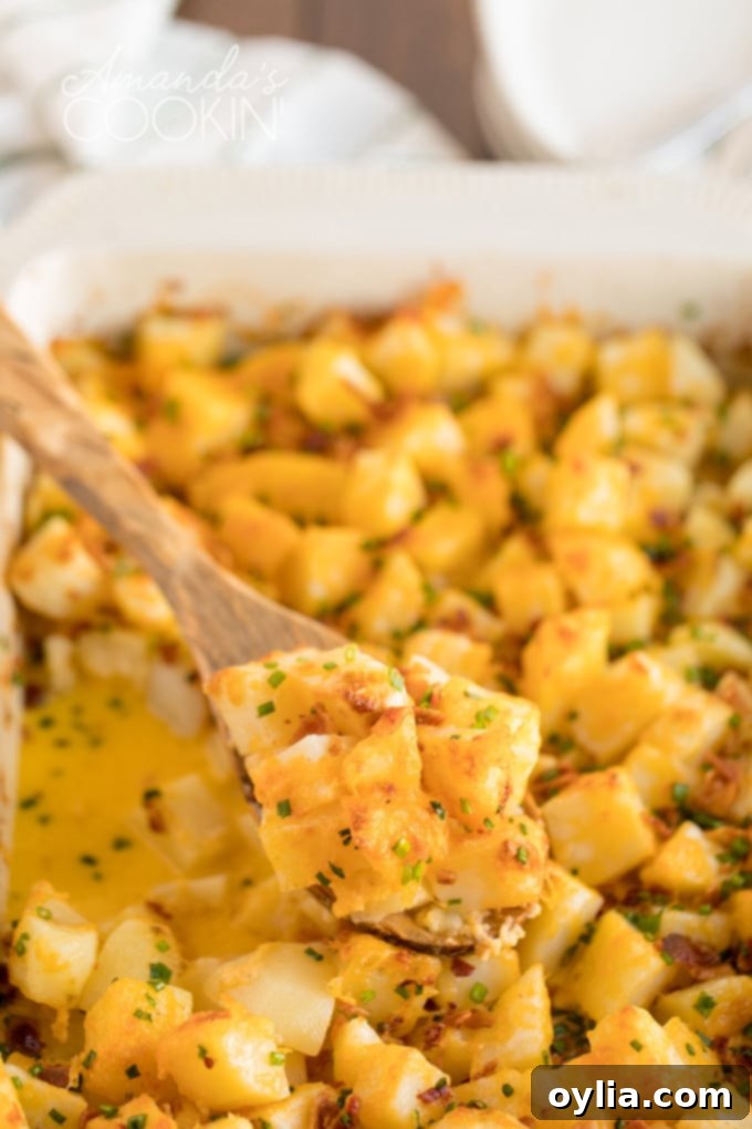 wooden spoon dipped in cheese potatoes casserole