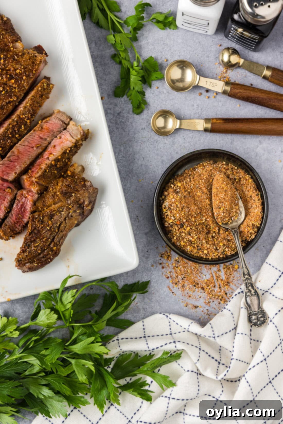 DIY Montreal Steak Rub 2 Bowl of Homemade Montreal Steak Seasoning with a spoon in it and cooked steak to the side