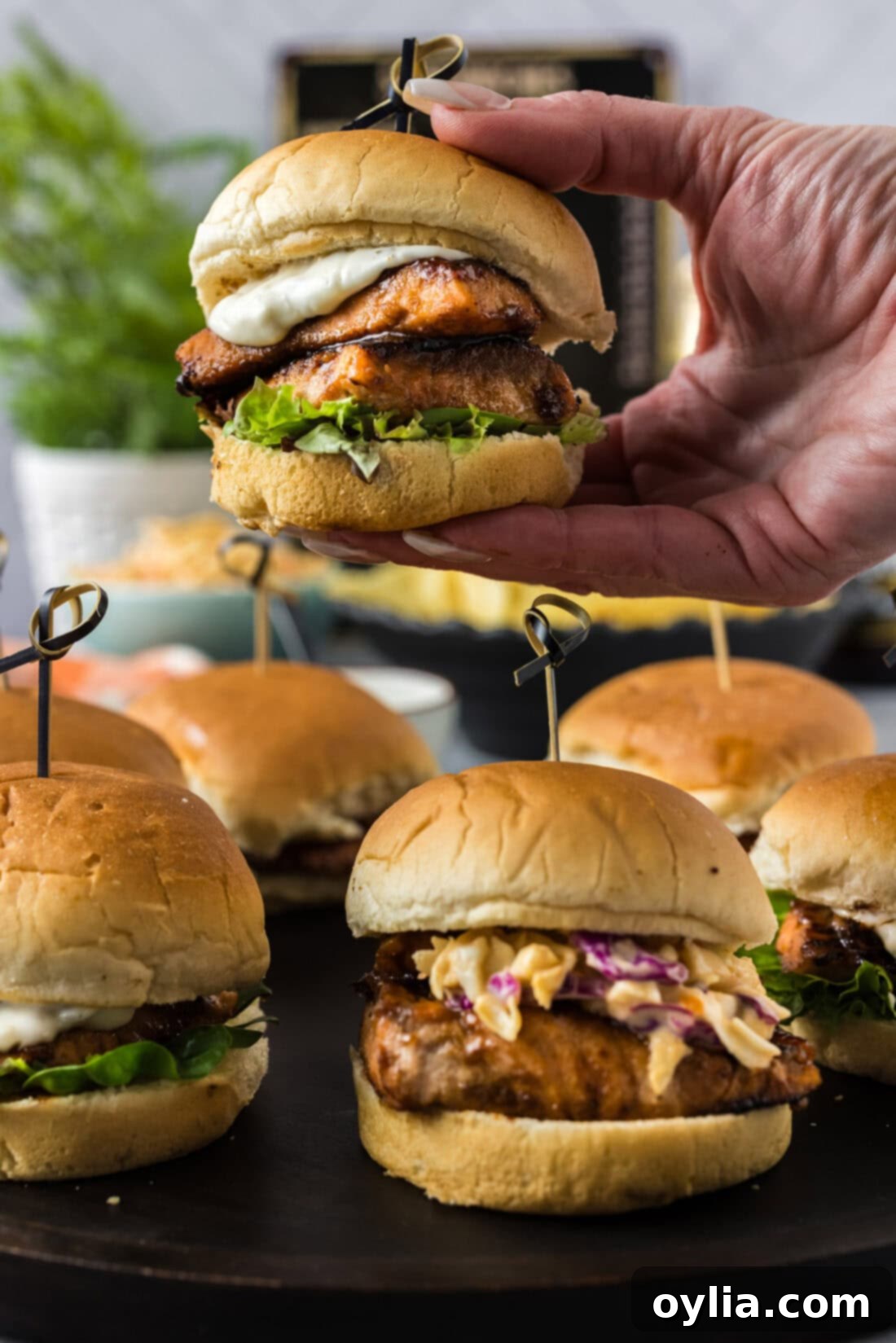 Gourmet Salmon Sliders 2 Hand holding a Salmon Slider above more sliders