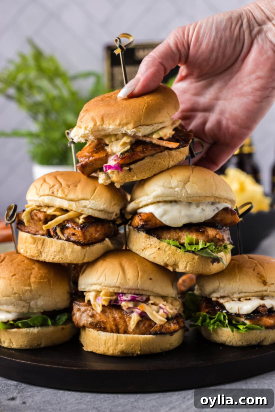 Gourmet Salmon Sliders 3 Hand placing a Salmon Slider on top a stack of Salmon Sliders