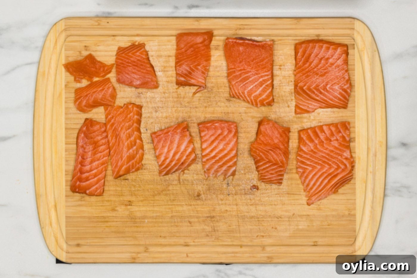 salmon cut into small portions on a cutting board