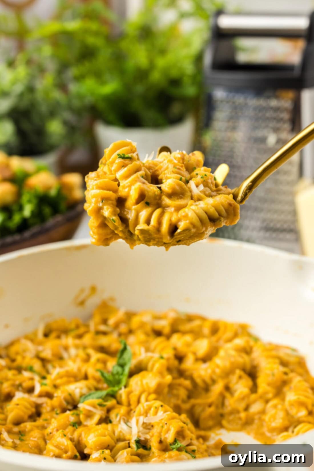 Serving spoon full of Butternut Squash Pasta held above a skillet