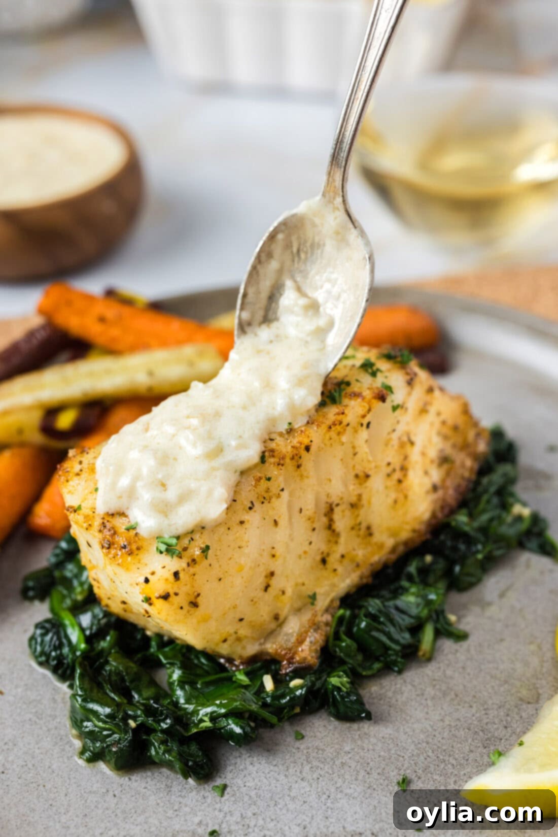 Perfectly Baked Chilean Sea Bass 2 Beurre Blanc Sauce being spooned over Baked Chilean Sea Bass