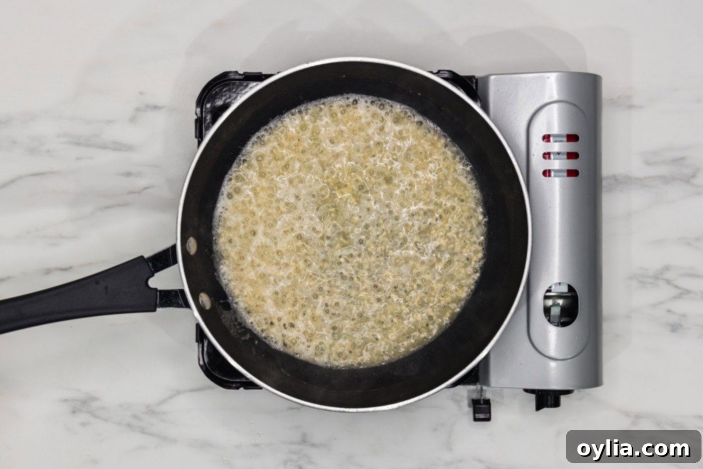 shallots and garlic cooking in butter in a skillet with wine