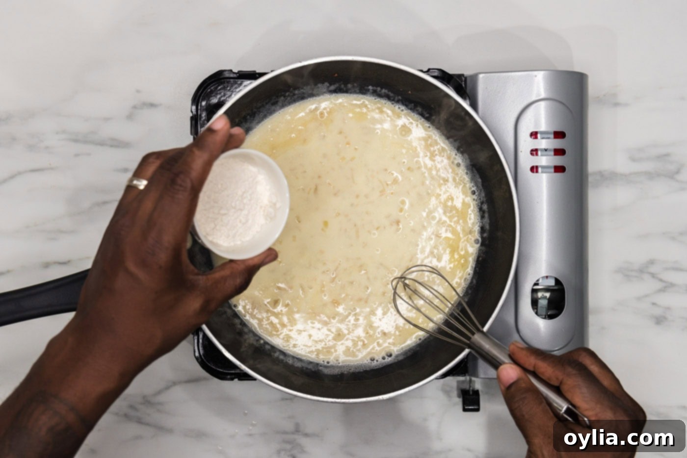 whisking flour into sauce in a skillet