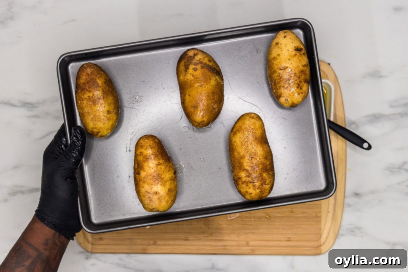 russet potatoes face down on a baking sheet